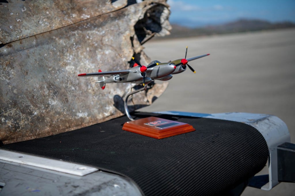 A model replica of the Lockheed P-38 Lightning “Marge” is placed in front of the recently recovered wing tip of the plane it is modeled after during a transfer ceremony in Port Moresby, Papua New Guinea