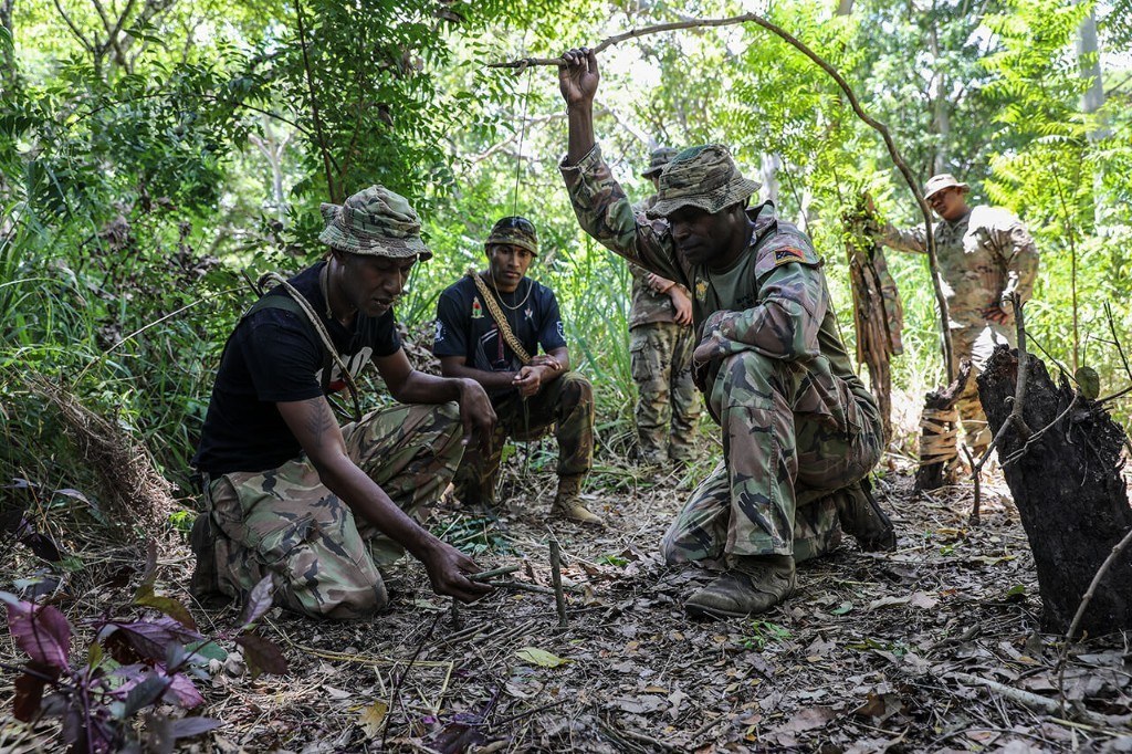 Soldiers learning jungle survival and trap–setting techniques